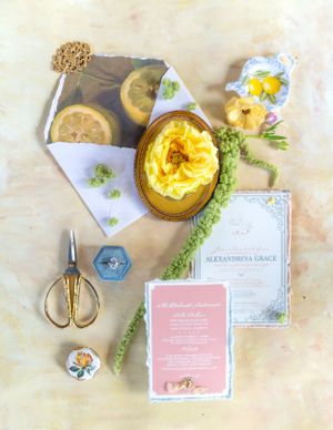 Wedding invitation flatlay with citrus details and yellow floral accents.