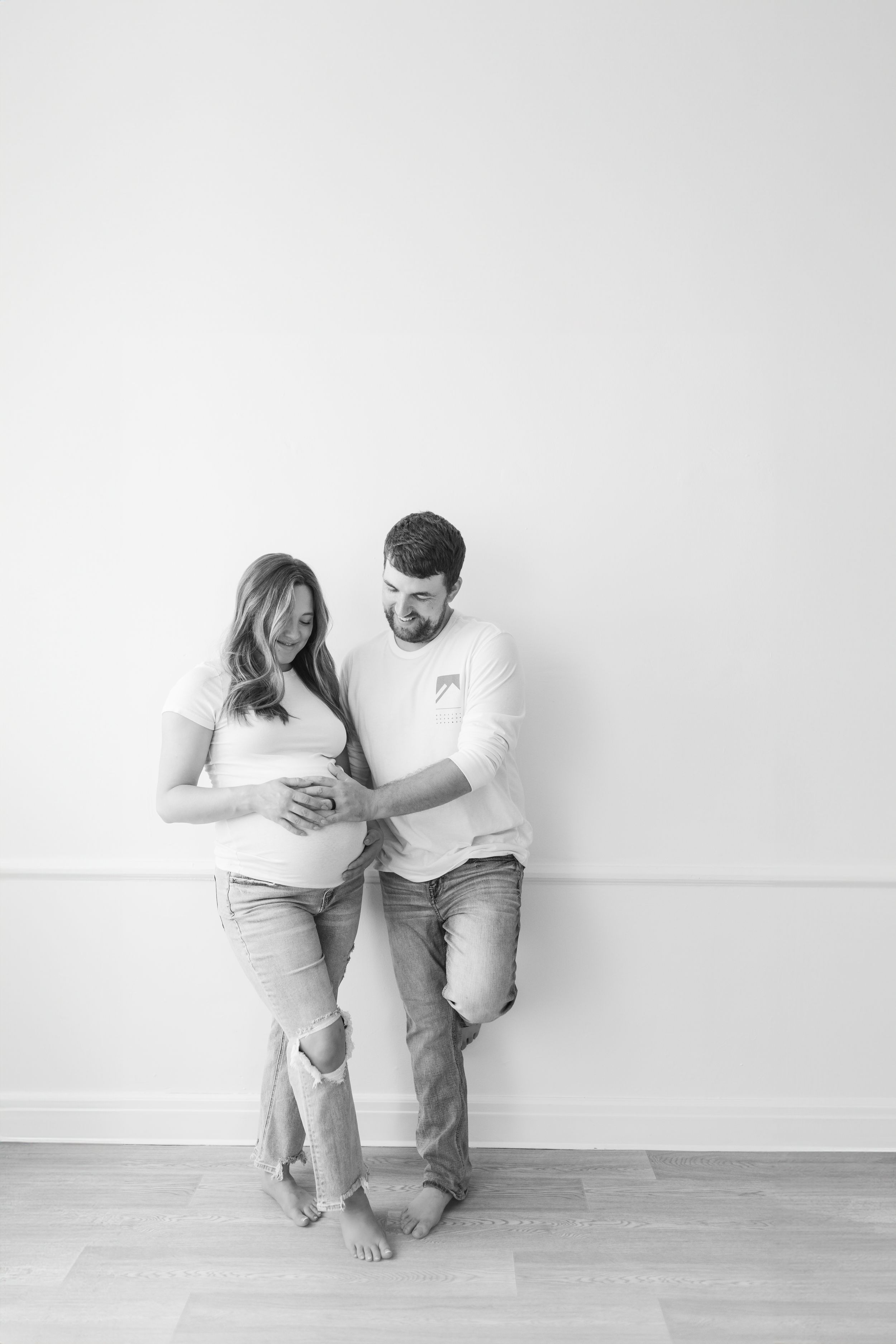 Minimalist black and white family maternity photo session on white background.