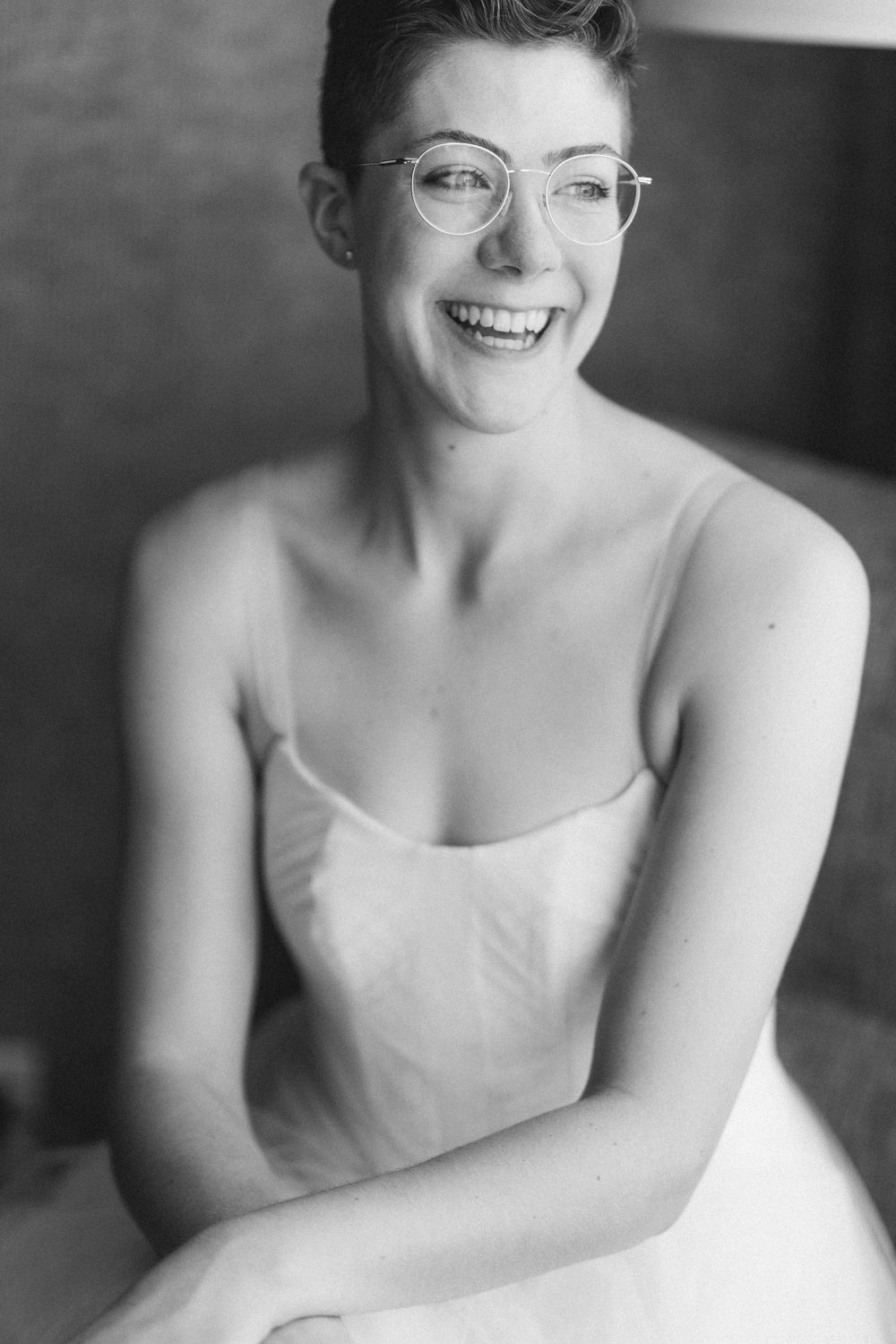 Black and white portrait in wedding attire with natural window lighting.