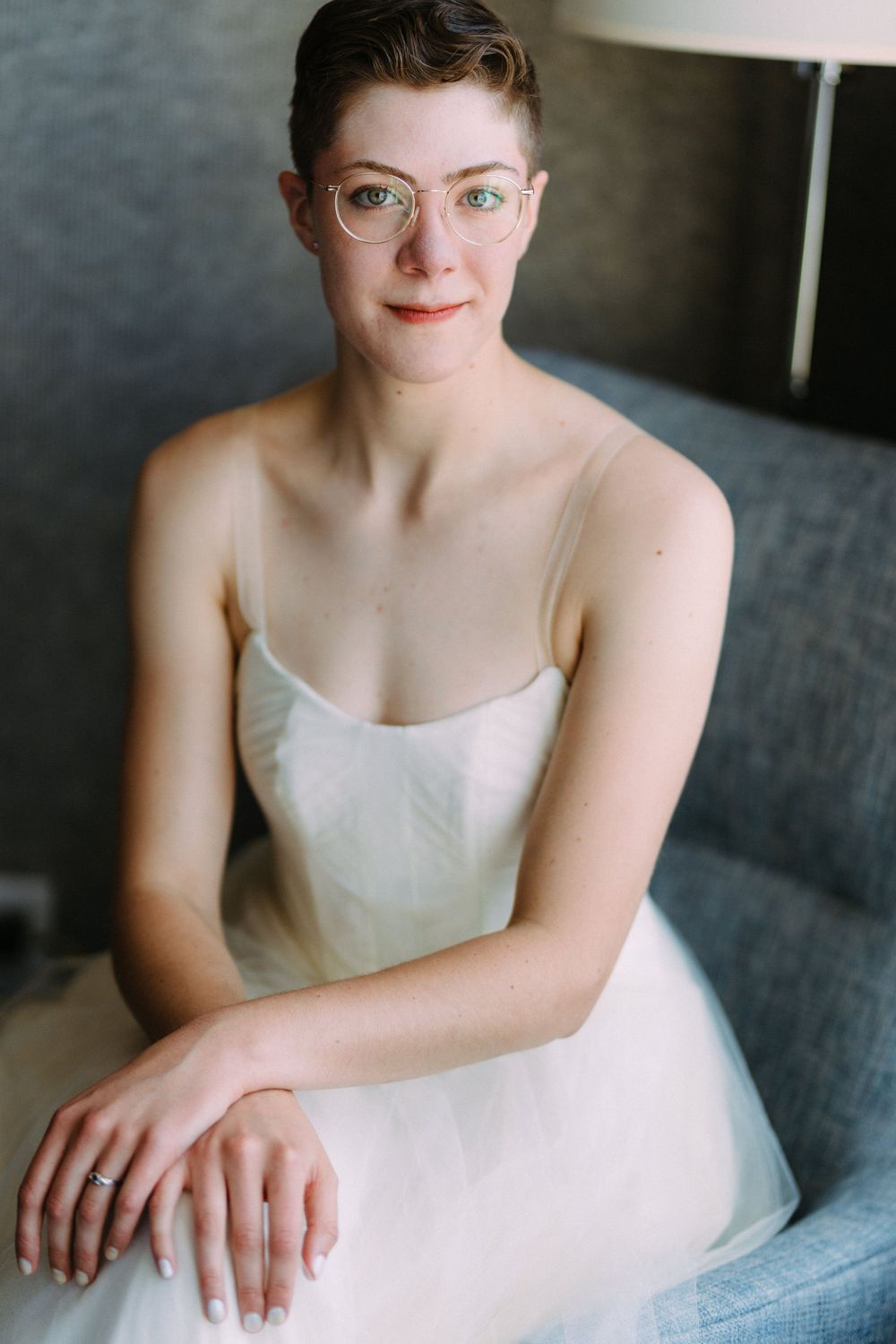 Close up portrait showing genuine smile while wearing formal white attire and glasses.