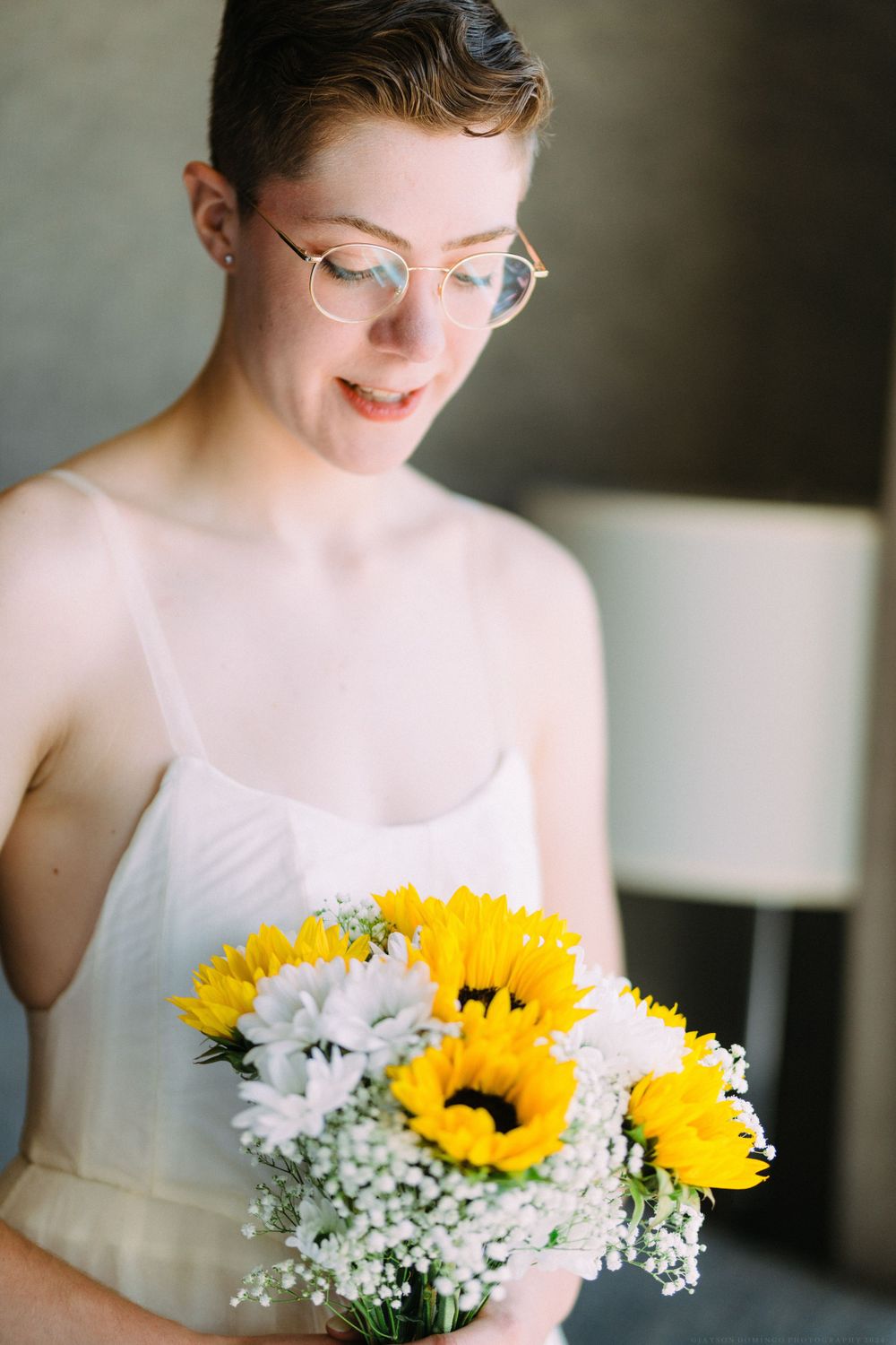 A wedding bouquet featuring bright yellow sunflowers and white baby's breath.
