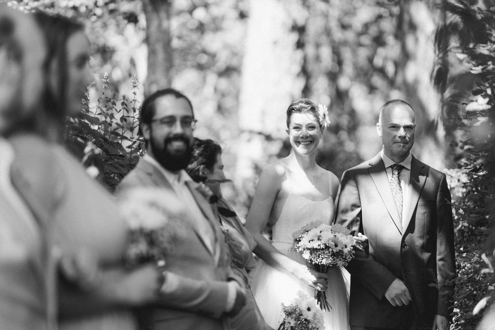 Black and white capture of wedding party members during an outdoor ceremony.