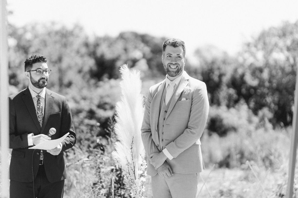 Black and white portrait of two people in formal attire at an outdoor event.