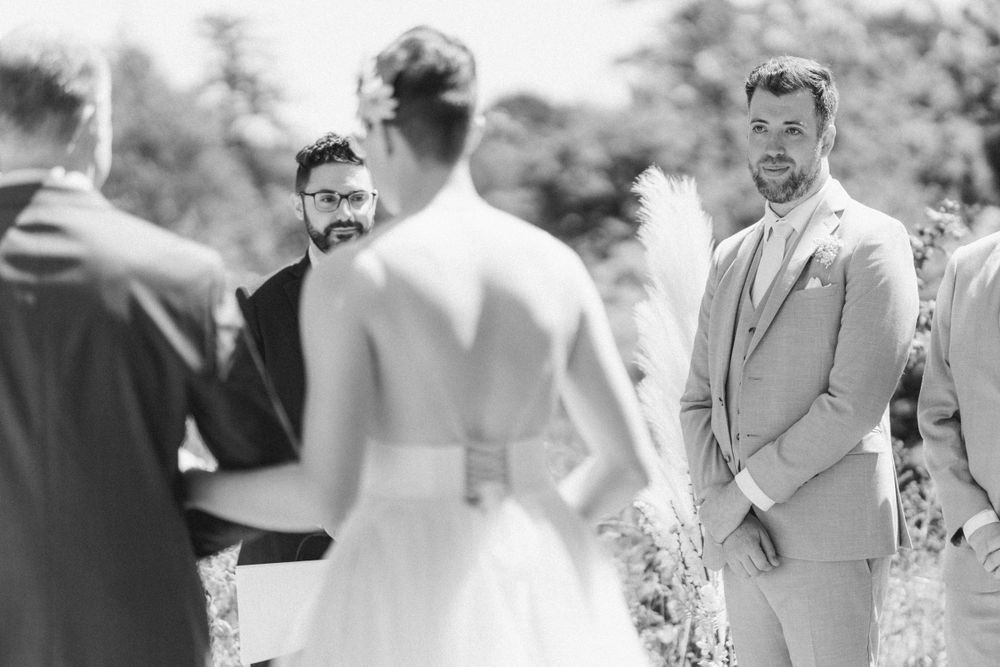 Black and white wedding ceremony photo capturing emotional reactions during vows.