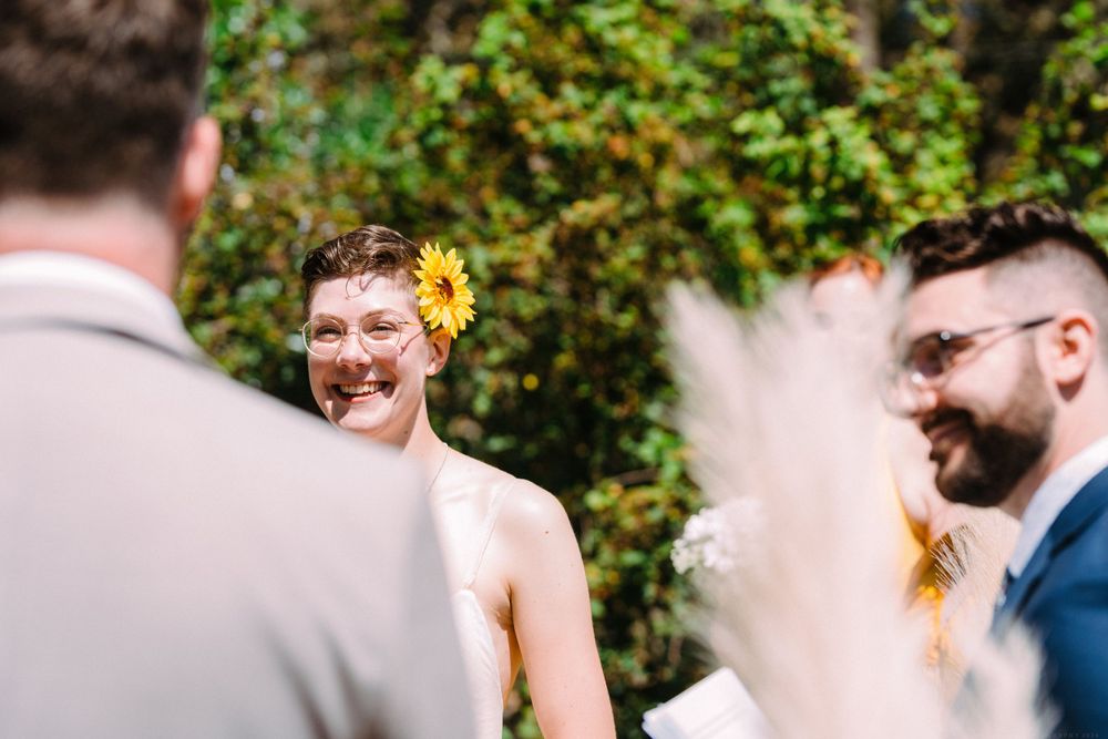 Joyful expressions are shared during a sunny outdoor wedding ceremony.