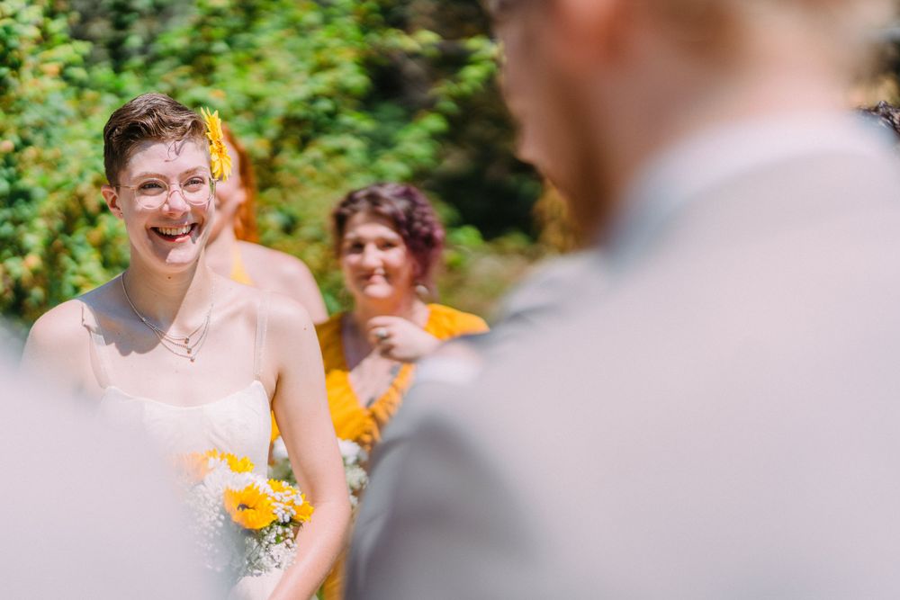 A happy moment is captured during an outdoor wedding with yellow floral accents.