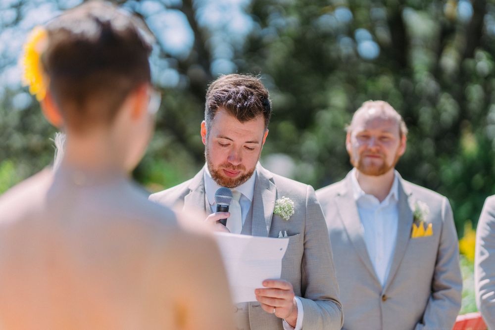 Emotional wedding ceremony moment as vows are read in an outdoor garden setting.