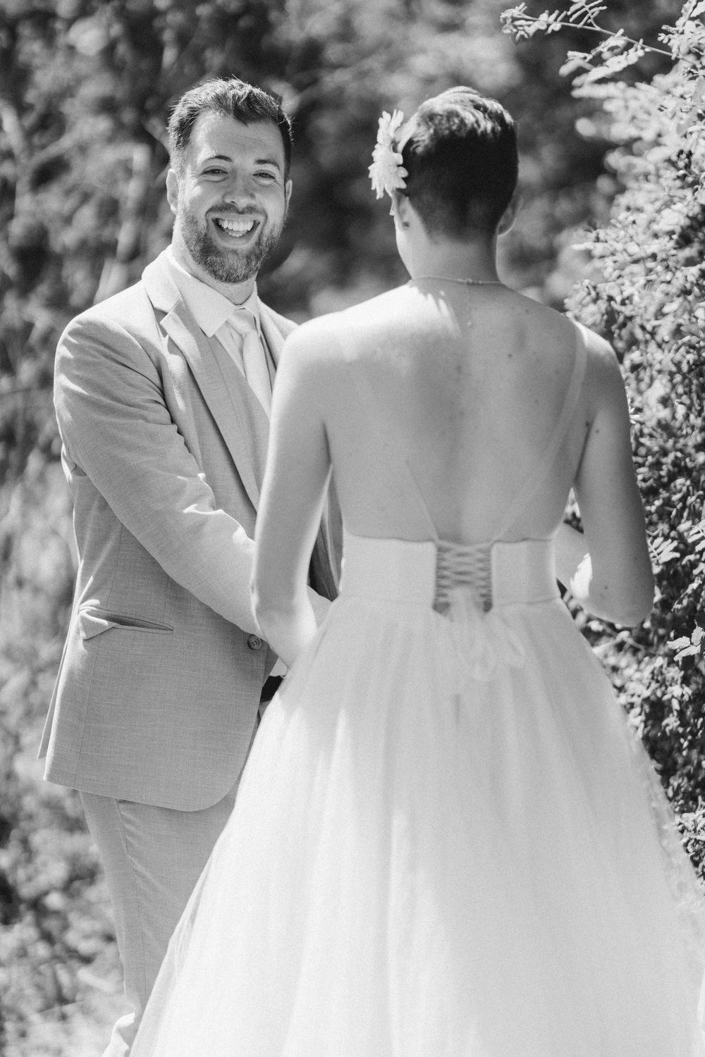 Black and white wedding portrait showing emotional first look moment outdoors.
