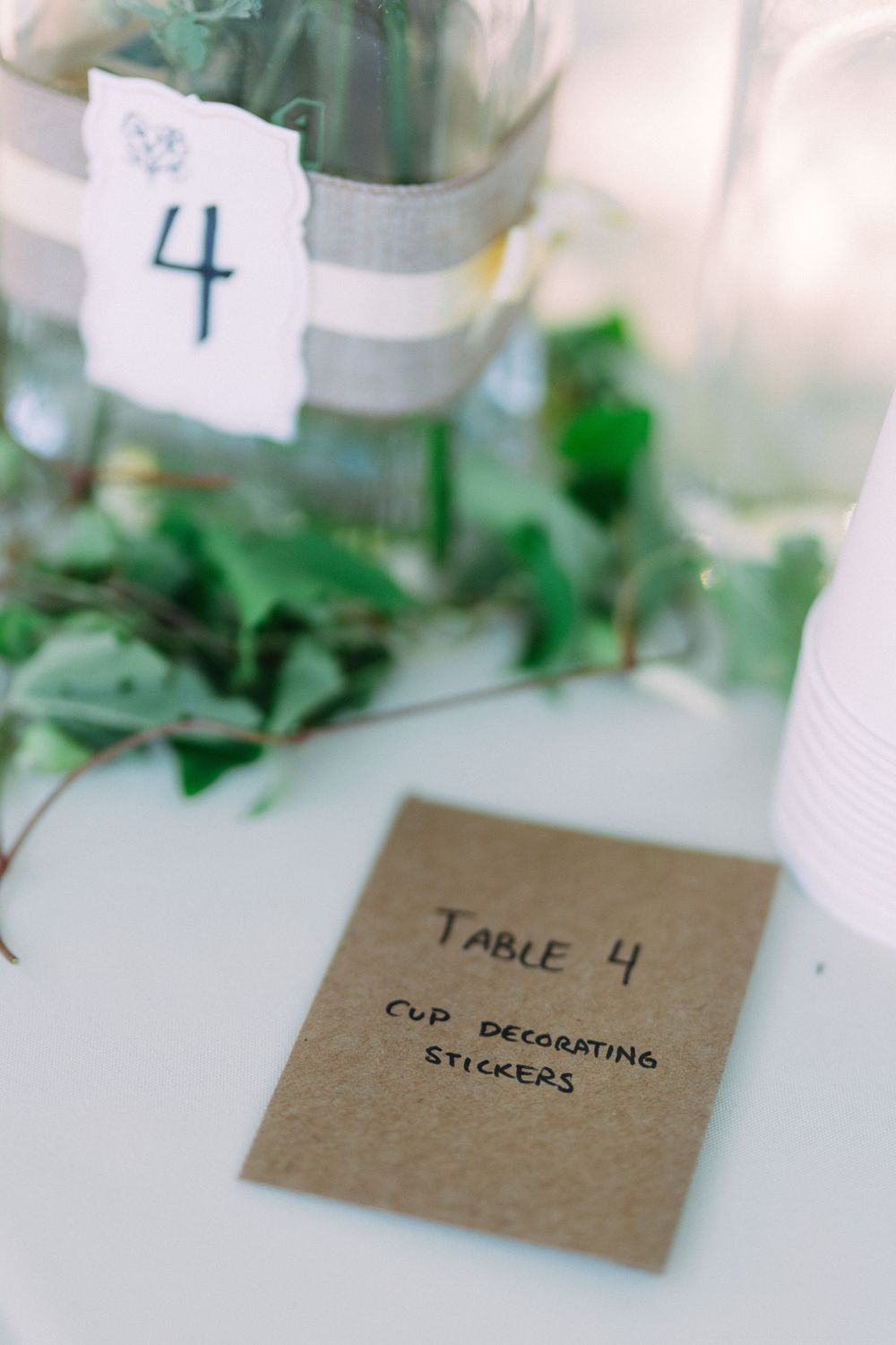 Wedding table number 4 card with cup decorating stickers text on kraft paper.
