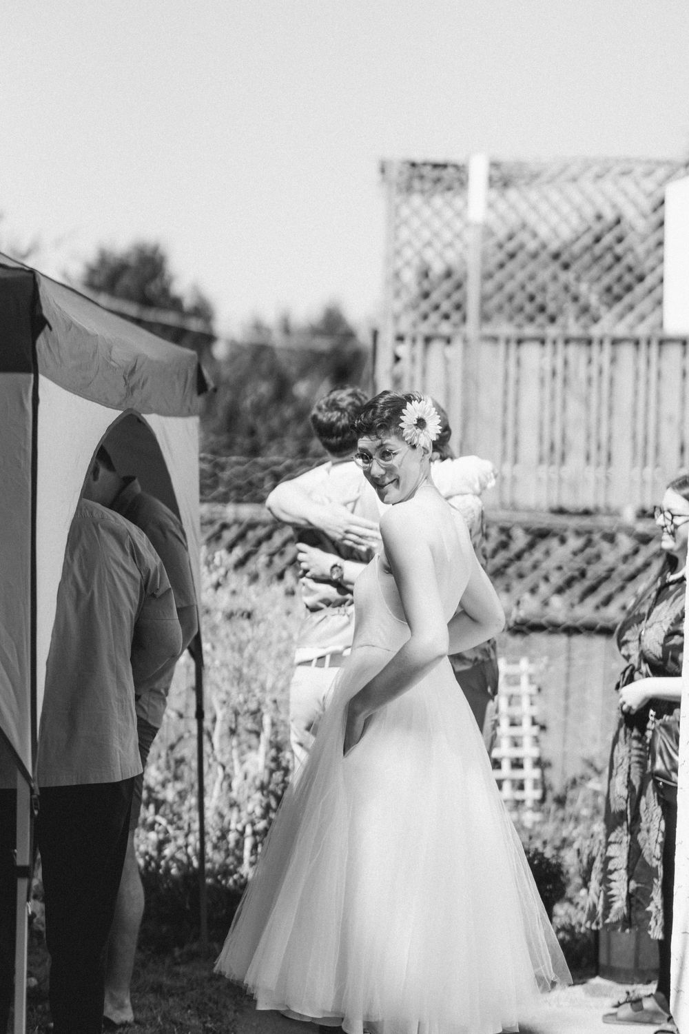 Black and white photo of a wedding celebration in a backyard garden setting.