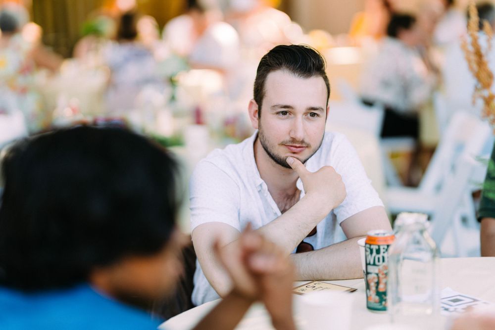 A guest in a white shirt engaged in conversation at a decorated table setting.