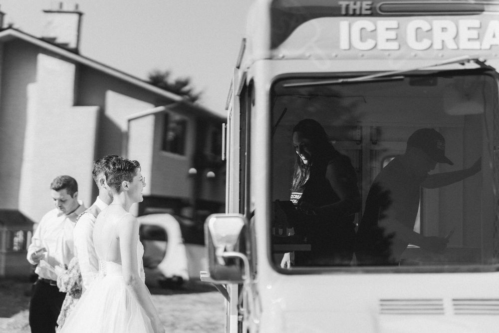 A black and white photo of people near an ice cream truck at a wedding.