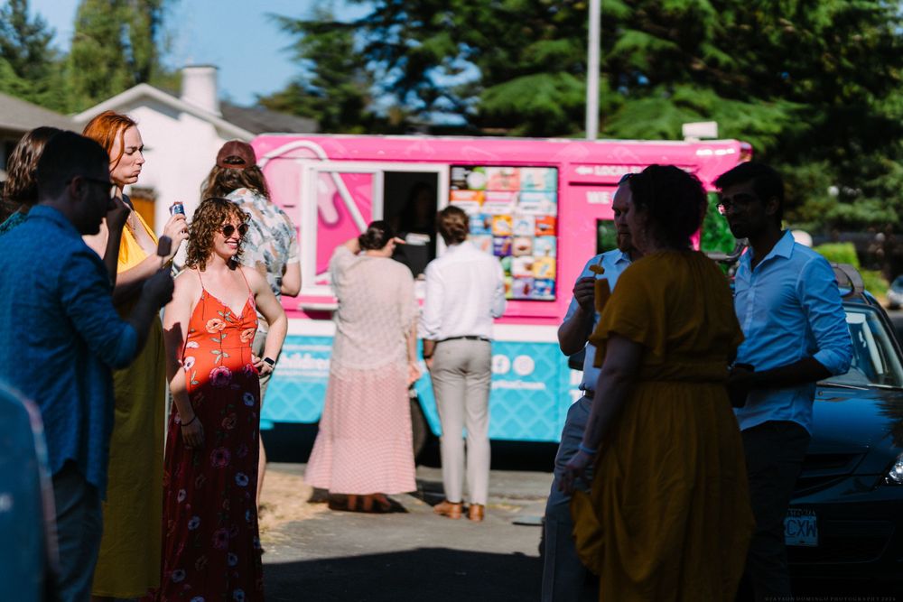 Guests gathered around colorful food trucks at an outdoor event.