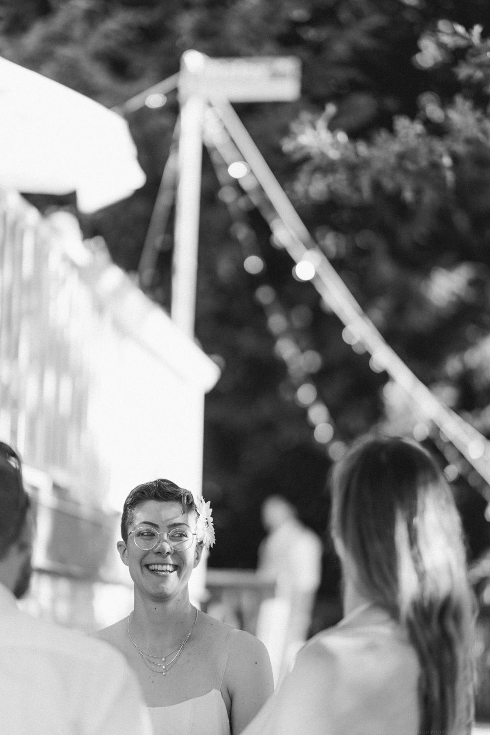 A candid black and white photo of guests enjoying an outdoor celebration.