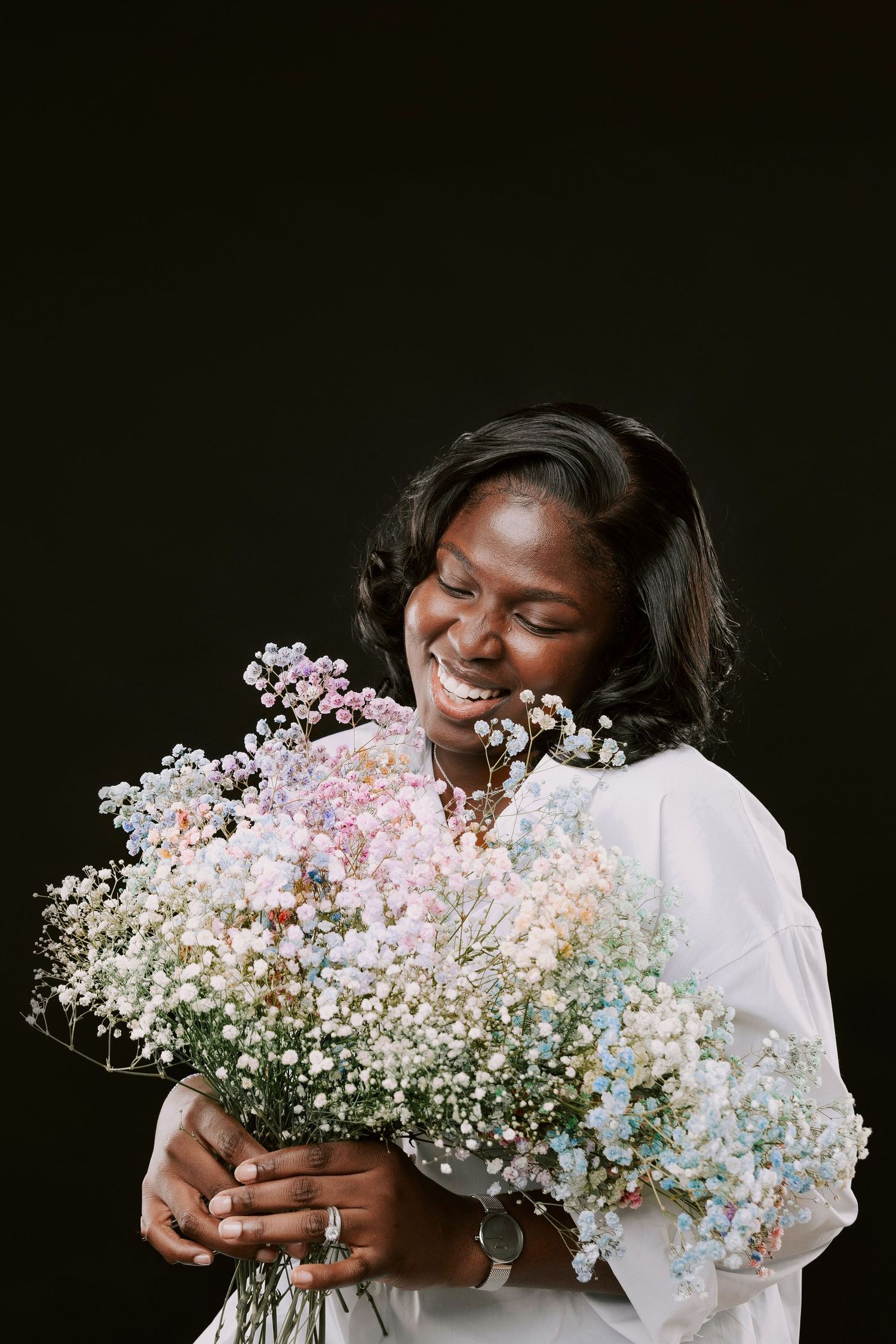 Glamour studio photo of a beautiful black woman wearing a casual fit on her 40th Birthday holding colourful flowers