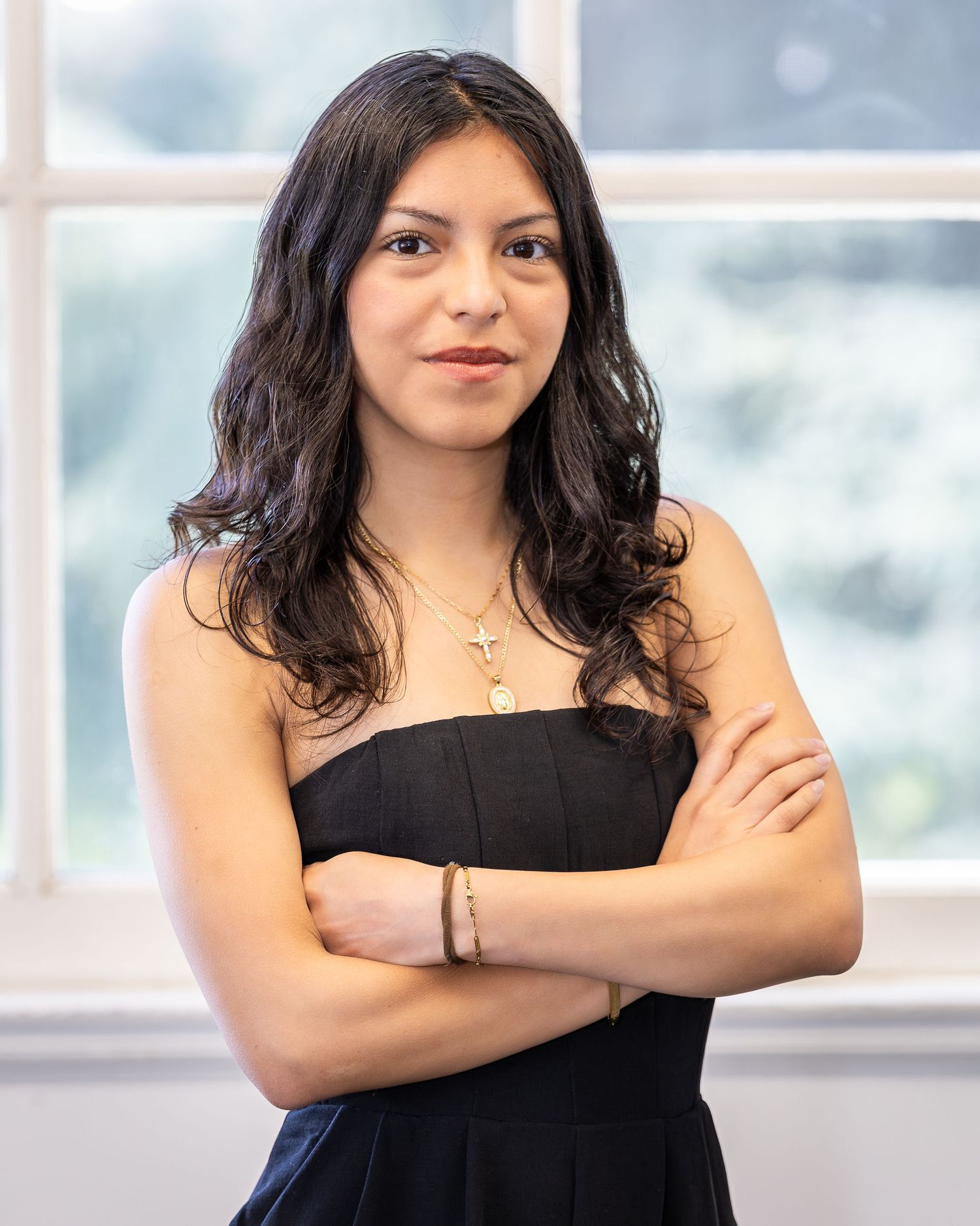 A female poses for a professional headshot taken by a professional photographer. The model poses in front of camera in a business pose.
