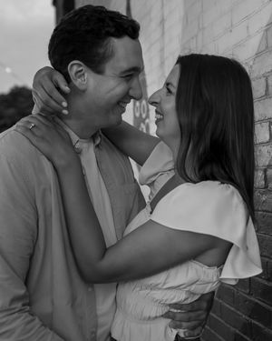 Engaged couple embracing in downtown Melrose, MA, where they first moved in together, captured by a Boston engagement ph