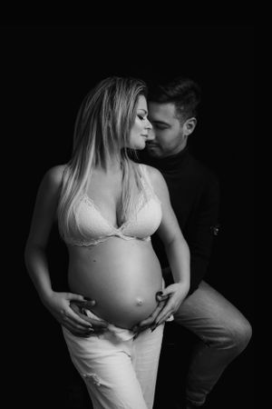 donna incinta abbracciata a suo marito
