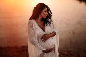 donna incinta in posa con il pancione al tramonto