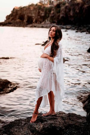 ragazza con il pancione in posa in riva al mare