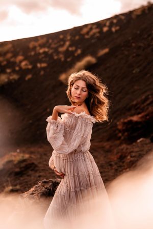 donna incinta in posa con il pancione al tramonto