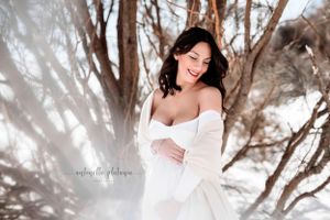 ragazza incinta in posa sorridente sulla neve