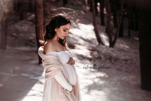 ragazza incinta accarezza il pancione sulla neve