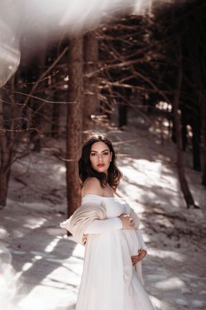 ragazza incinta in posa sulla neve in montagna
