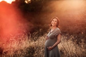 donna incinta in posa con il pancione al tramonto