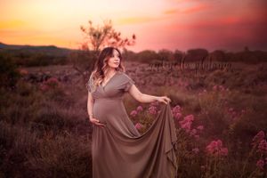 donna incinta in posa con il pancione al tramonto
