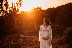 donna incinta in posa con il pancione al tramonto