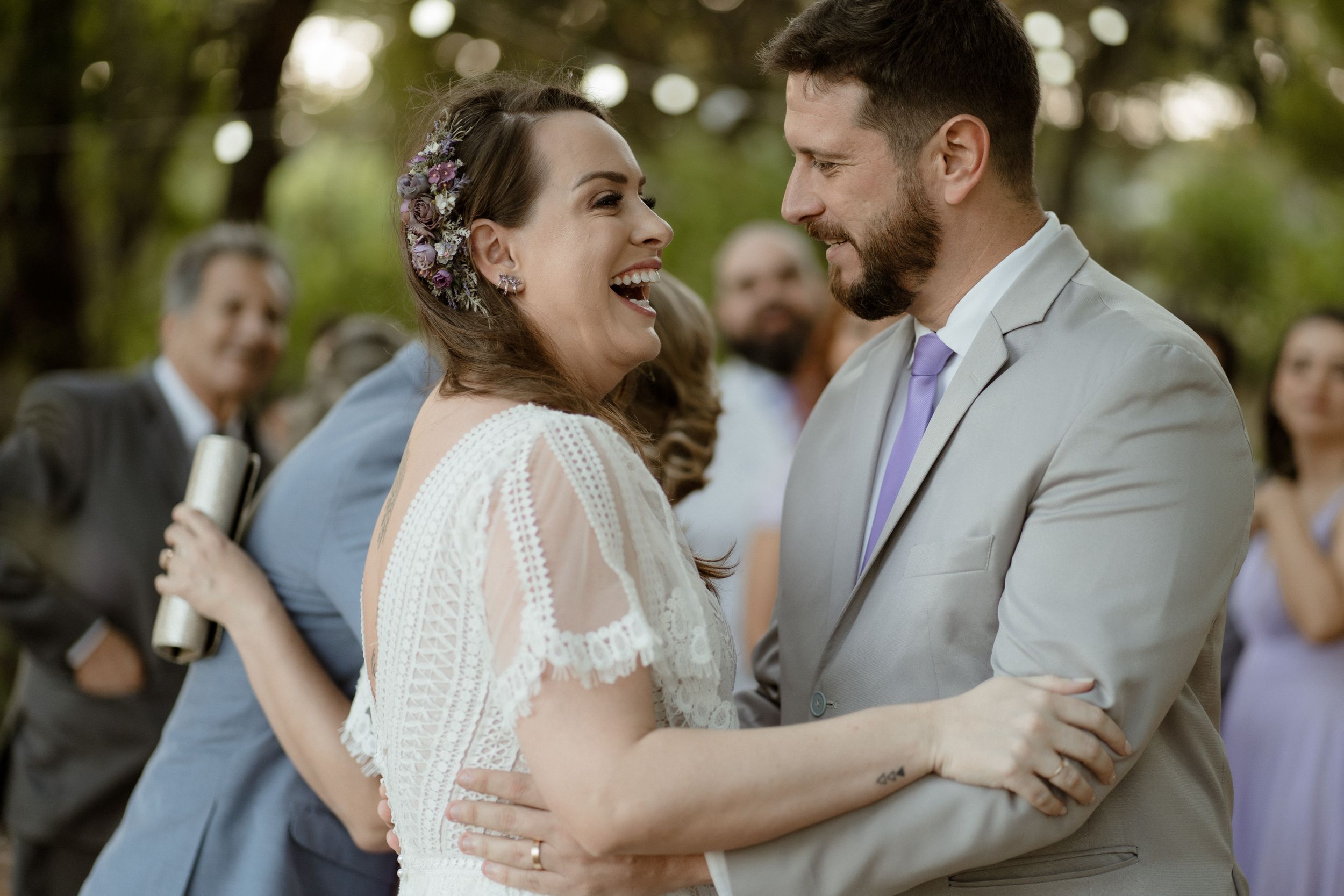 Guests share emotional embraces at outdoor wedding reception.