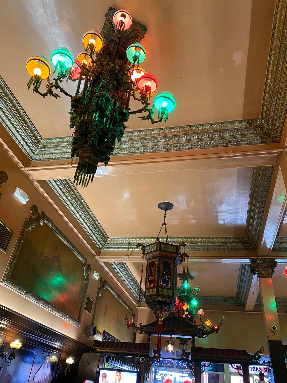 Ornate vintage chandelier with colorful glass globes in an historic interior.