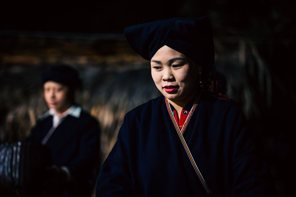Traditional dark clothing and headdress in cultural setting.