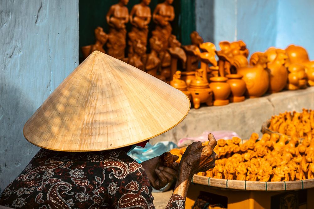 Traditional conical hat and local goods displayed at Vietnamese market stall.