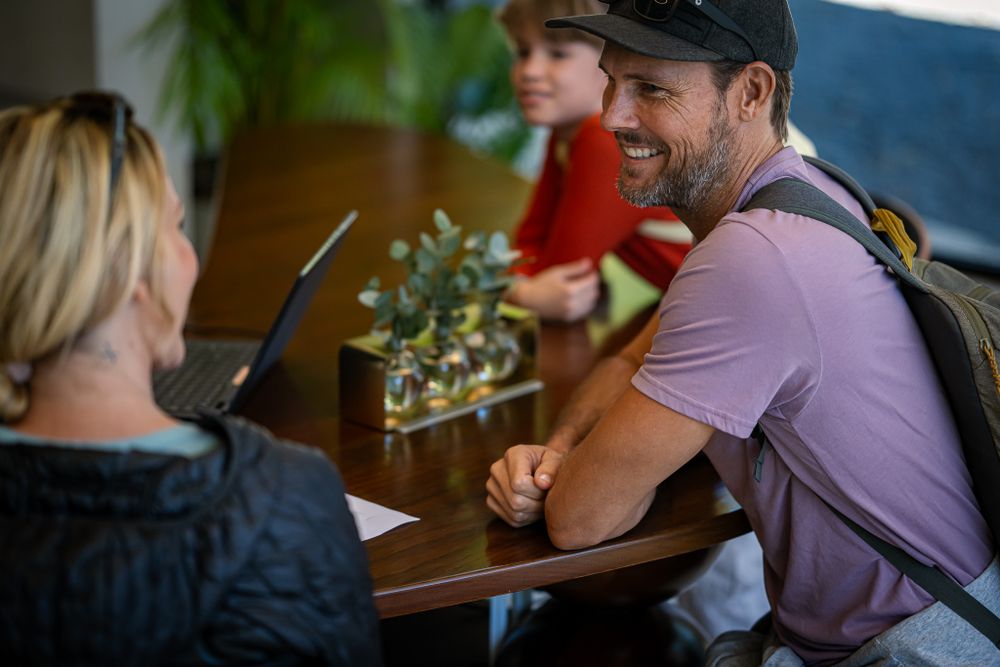 Group gathered around wooden table in casual dining setting.