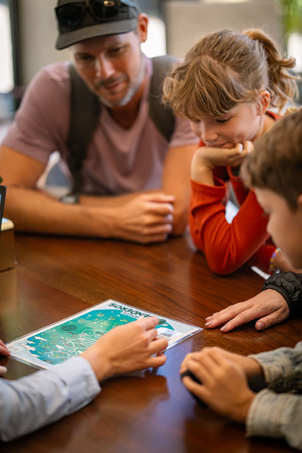 People looking at map together at wooden table.