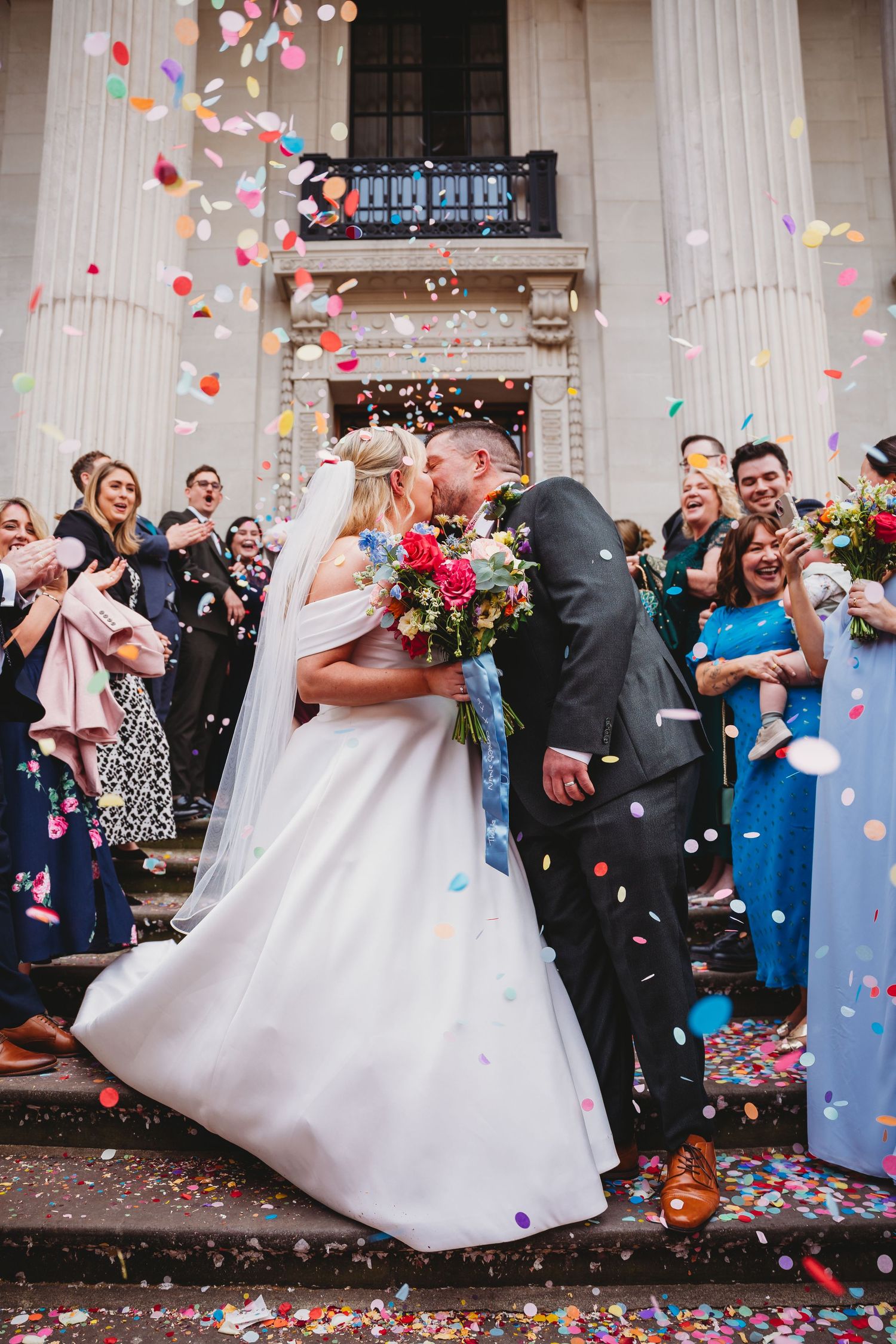 Joyful wedding party showered with confetti during outdoor celebration at Marylebone Town Hall, London