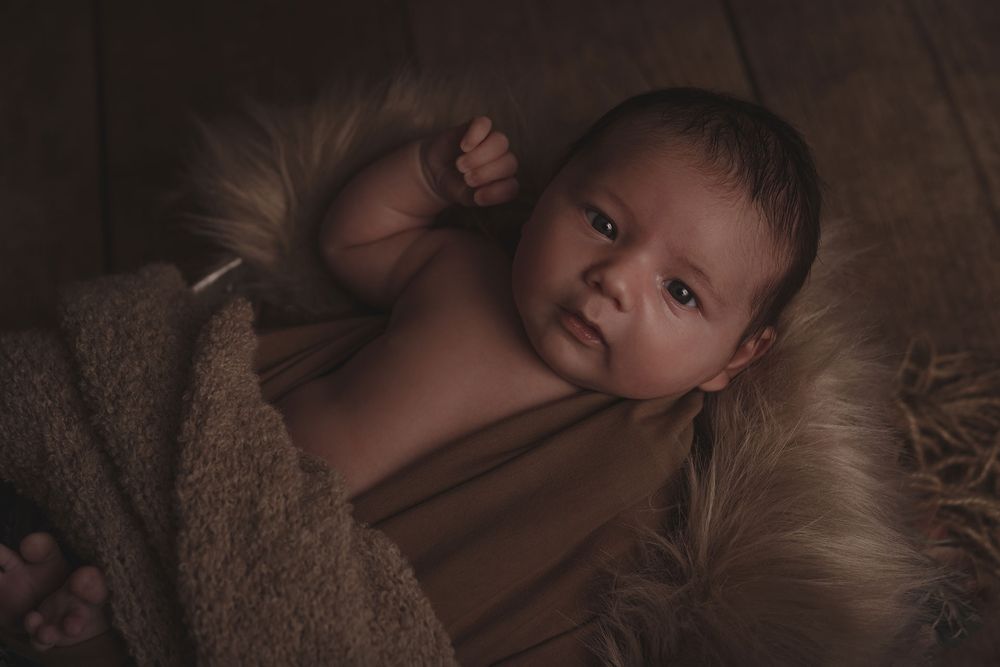 Photographie d'un bébé éveillé lors d'une séance naissance réalisée par Amandine Chiriaeff à Saint Pierre Aigle