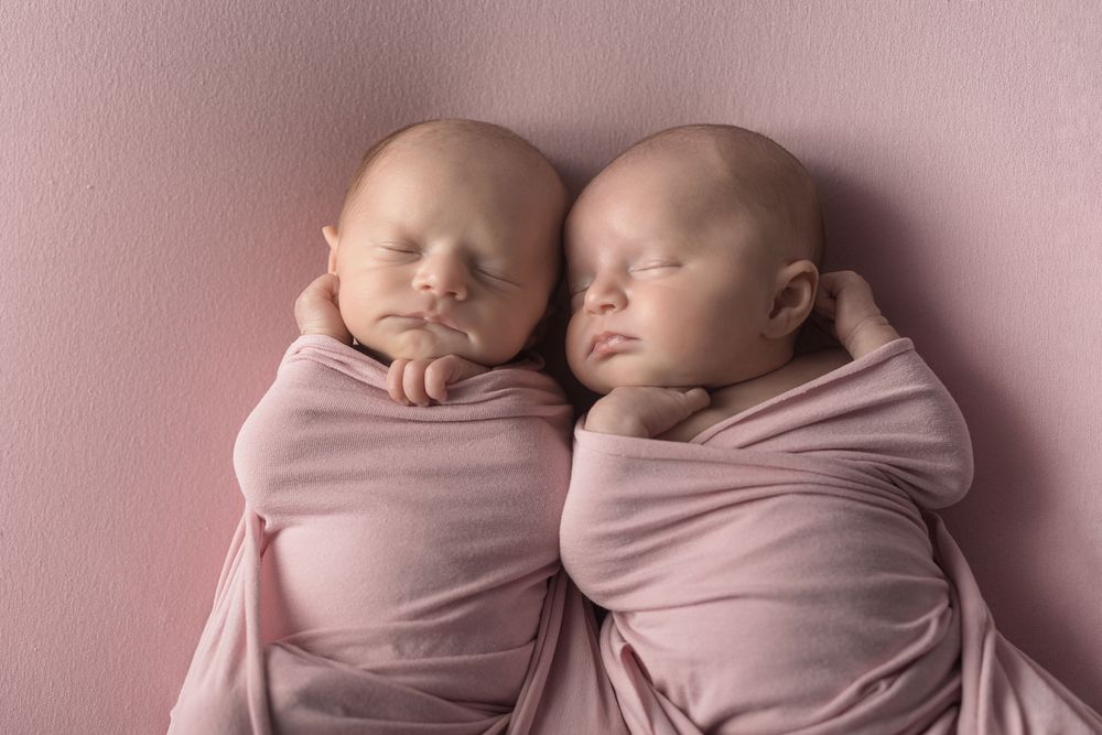 Photographie de jumeaux nourrissons emmaillotés réalisée par Amandine Chiriaeff dans un studio à Paris