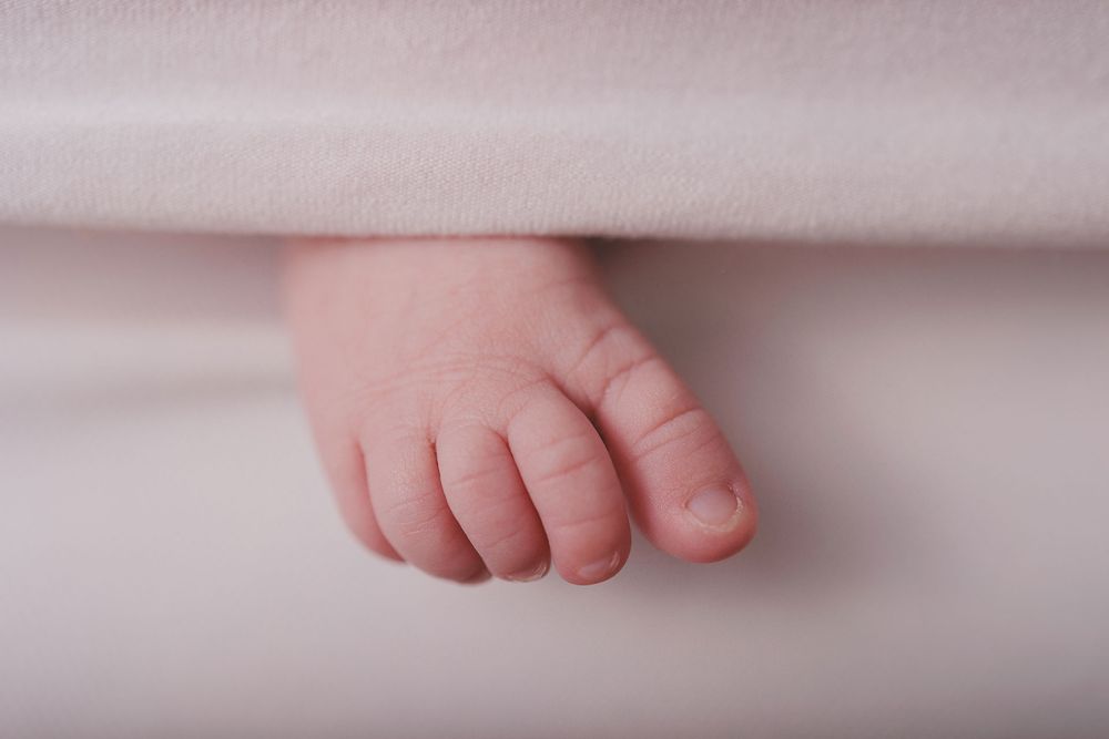 Photographie de détail d'un petit pied de nourrisson réalisée lors d'une séance naissance studio par Amandine Chiriaeff
