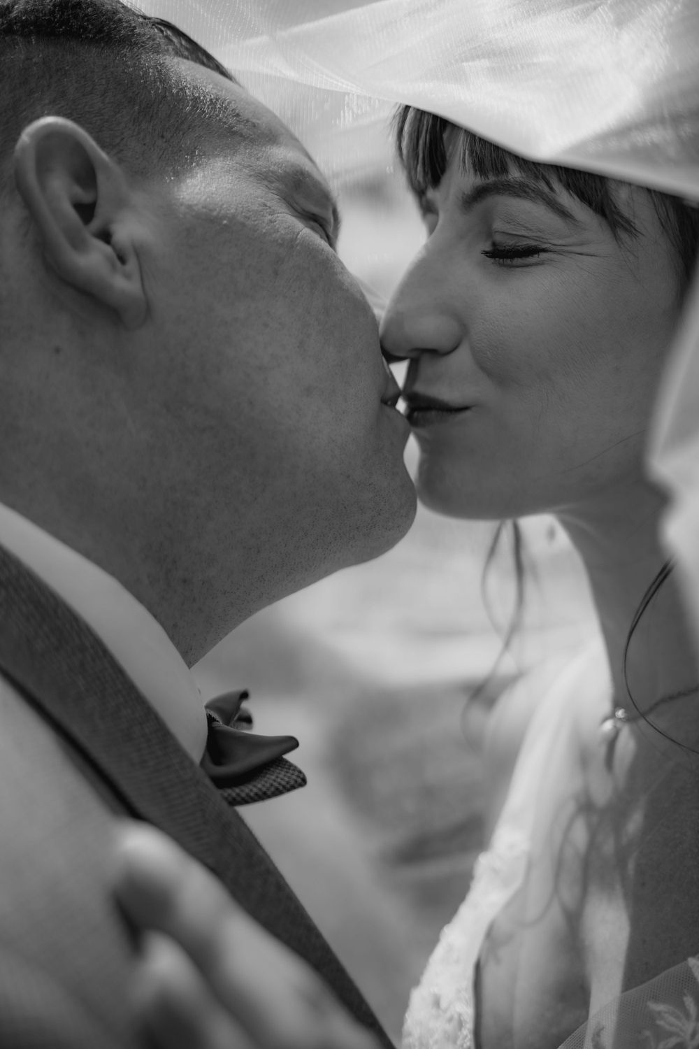 Intimate black and white close-up of tender wedding moment.