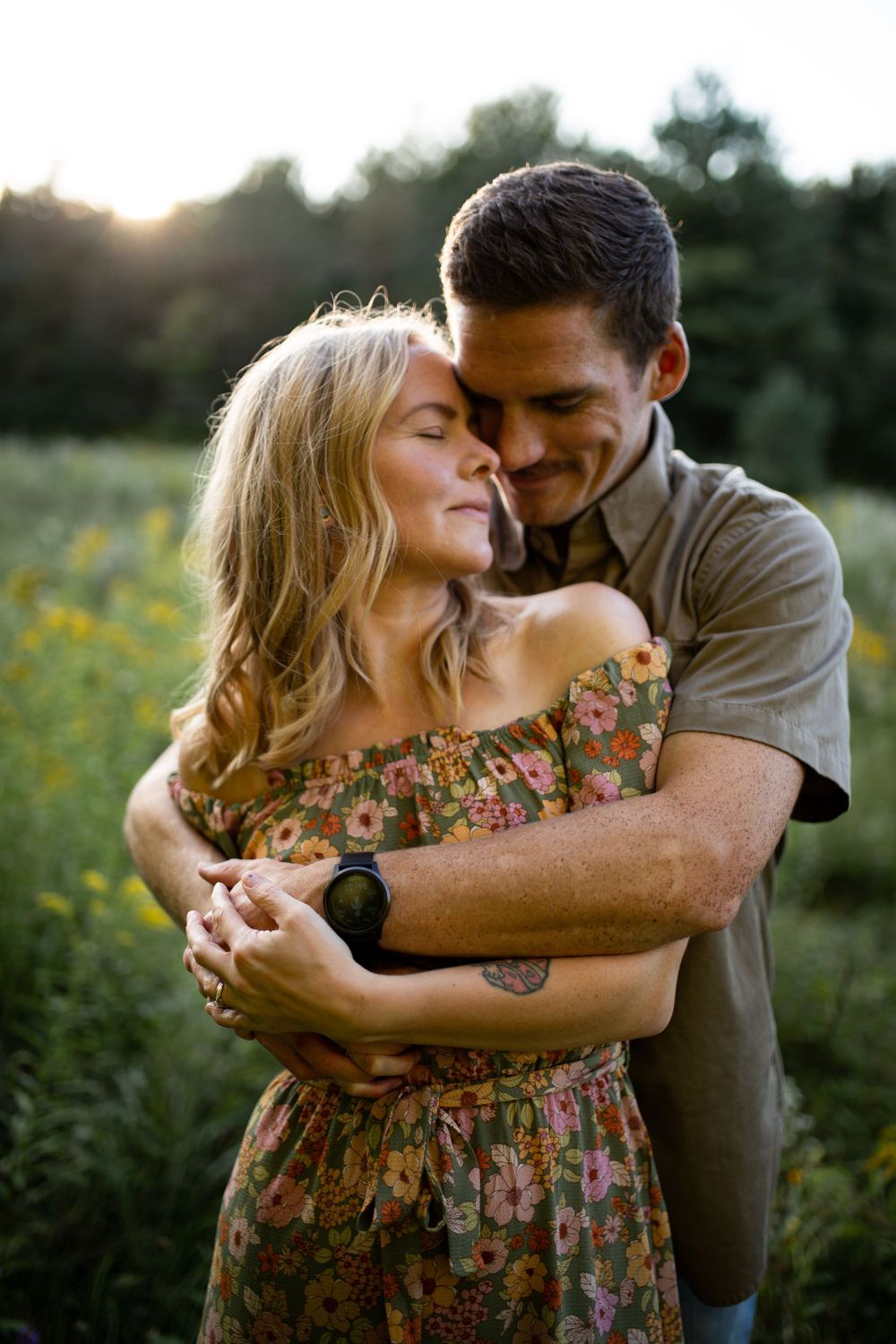 Intimate moment between couple in floral dress and casual shirt at golden hour.