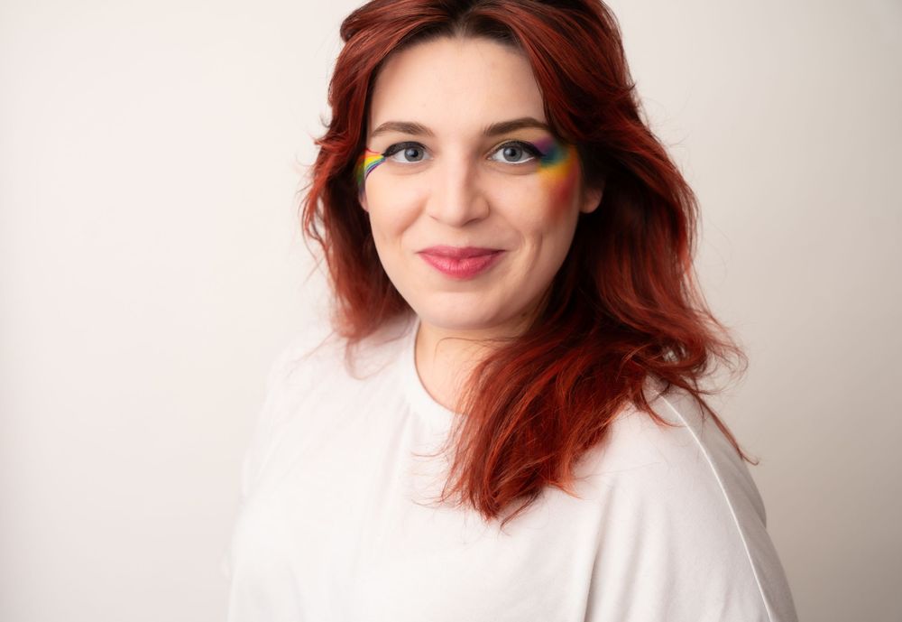 A joyful expression amidst a white background wearing a simple white top.