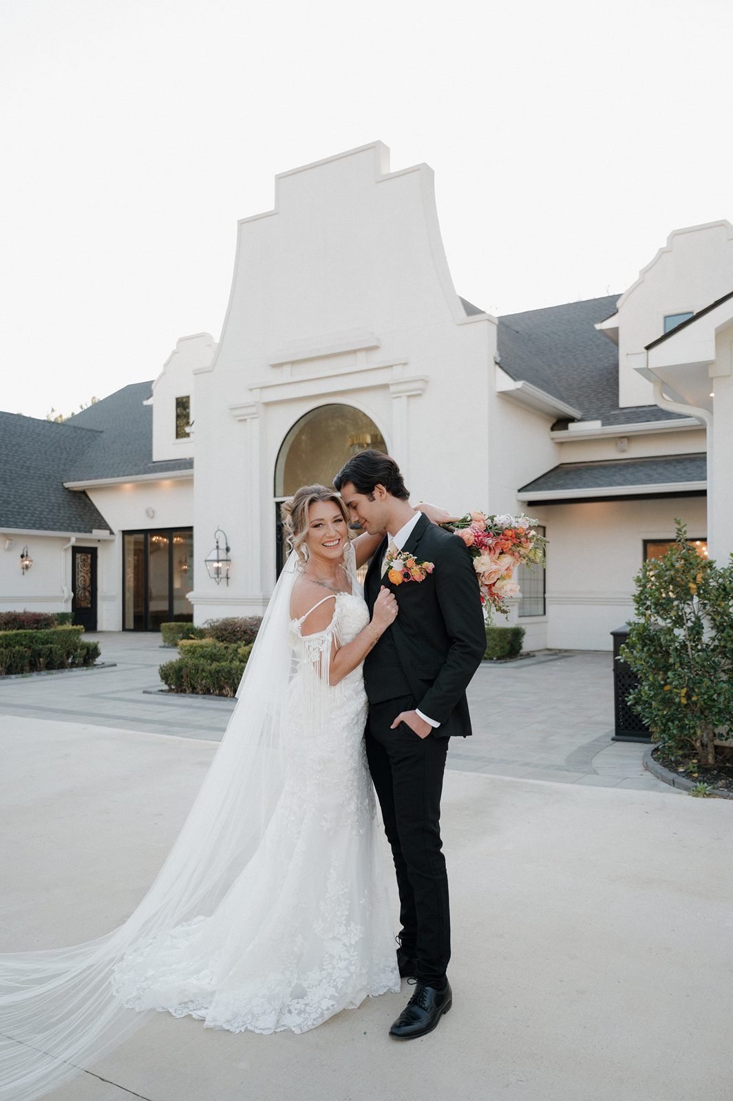 bride and groom standing face to face in front of Peach Orchard wedding venue