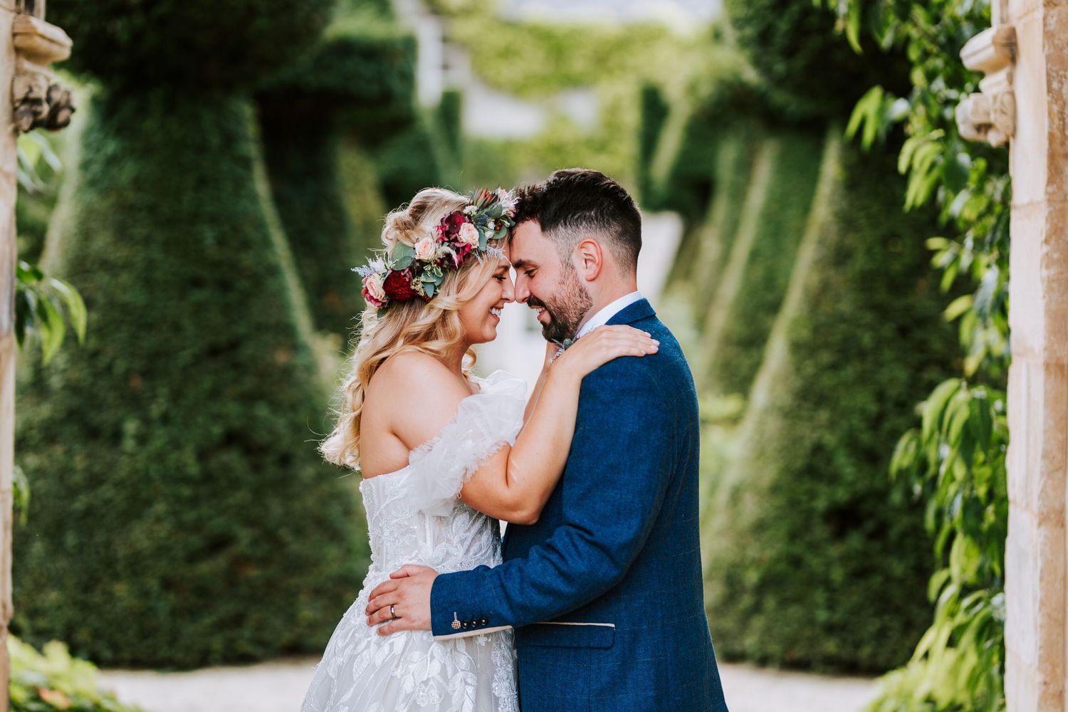 Garden wedding portraits amidst lush greenery and manicured hedges.