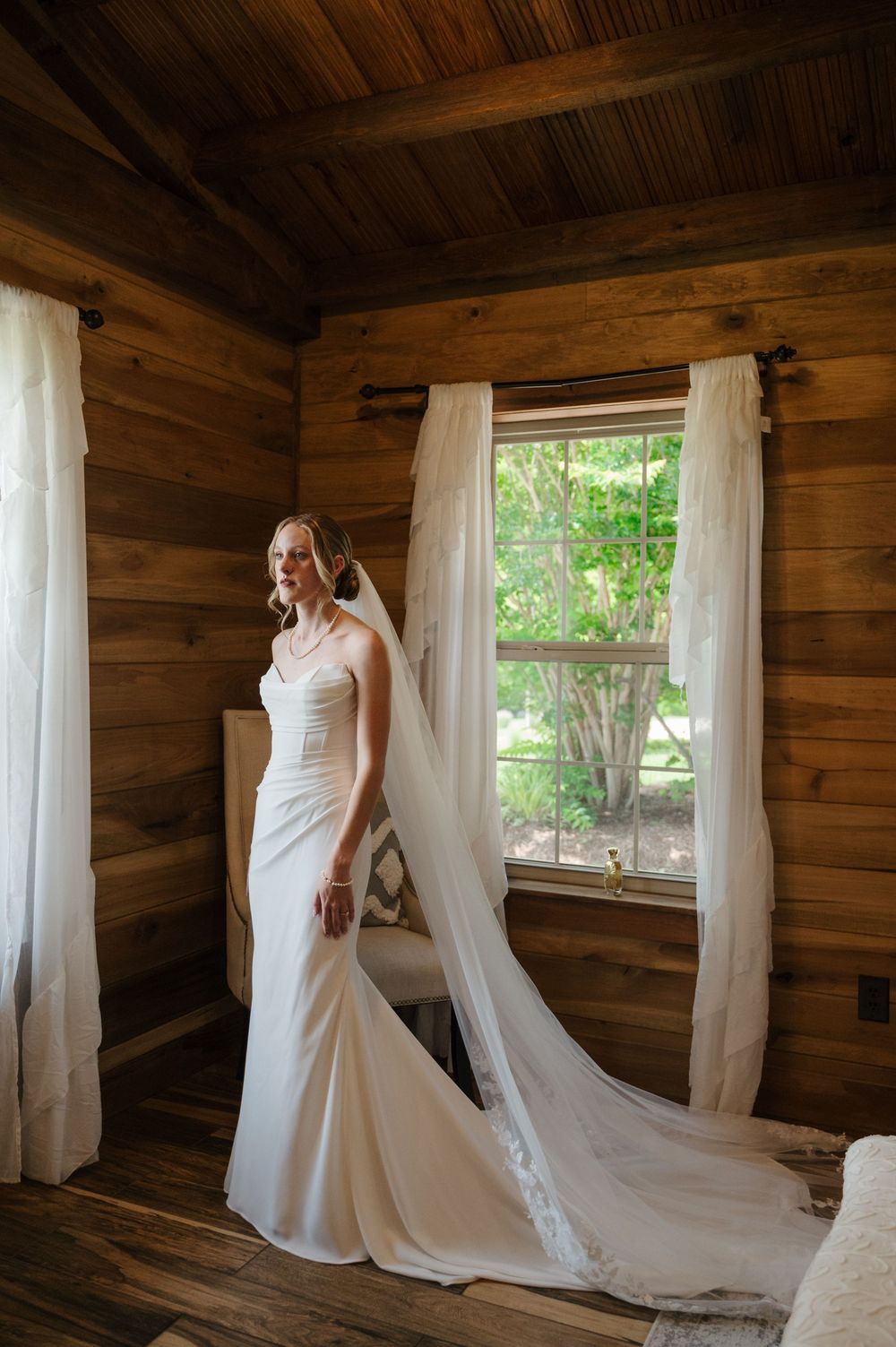 Bride getting ready for wedding in front of window