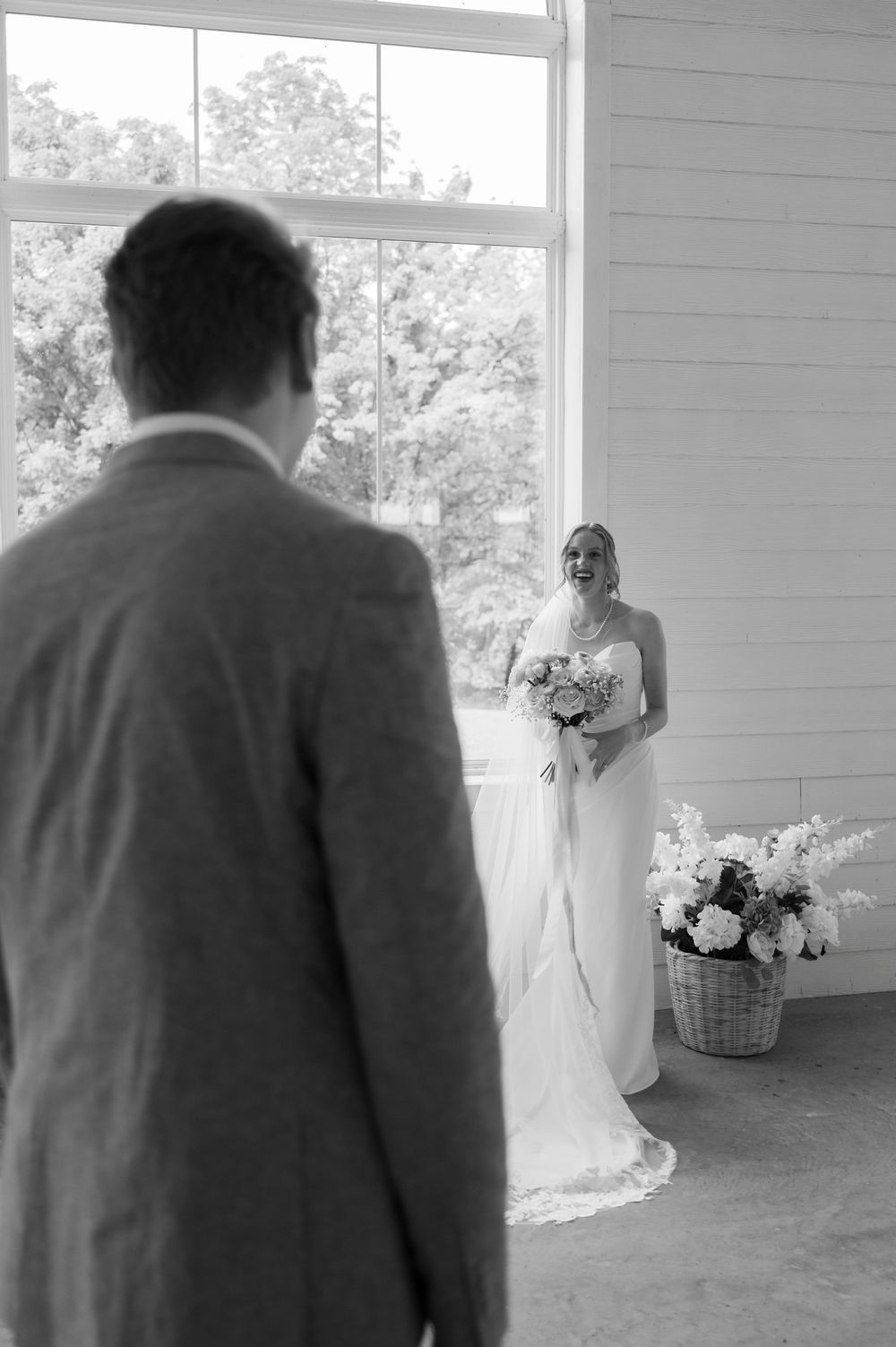 Black and white photo of groom looking at bride