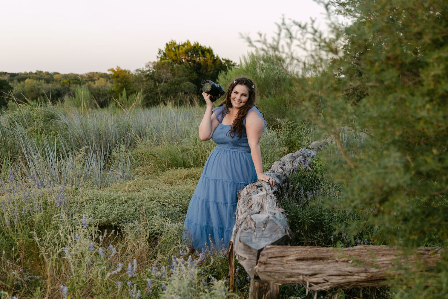 A couple walks hand in hand down a nature path surrounded by tall grass.