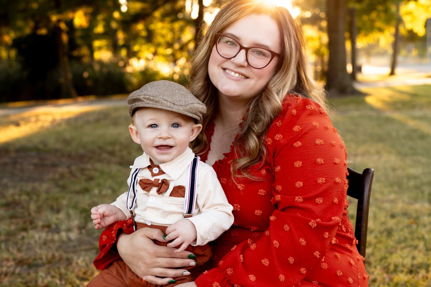 Outdoor portrait in golden sunlight with red polka dot dress and fall decor.